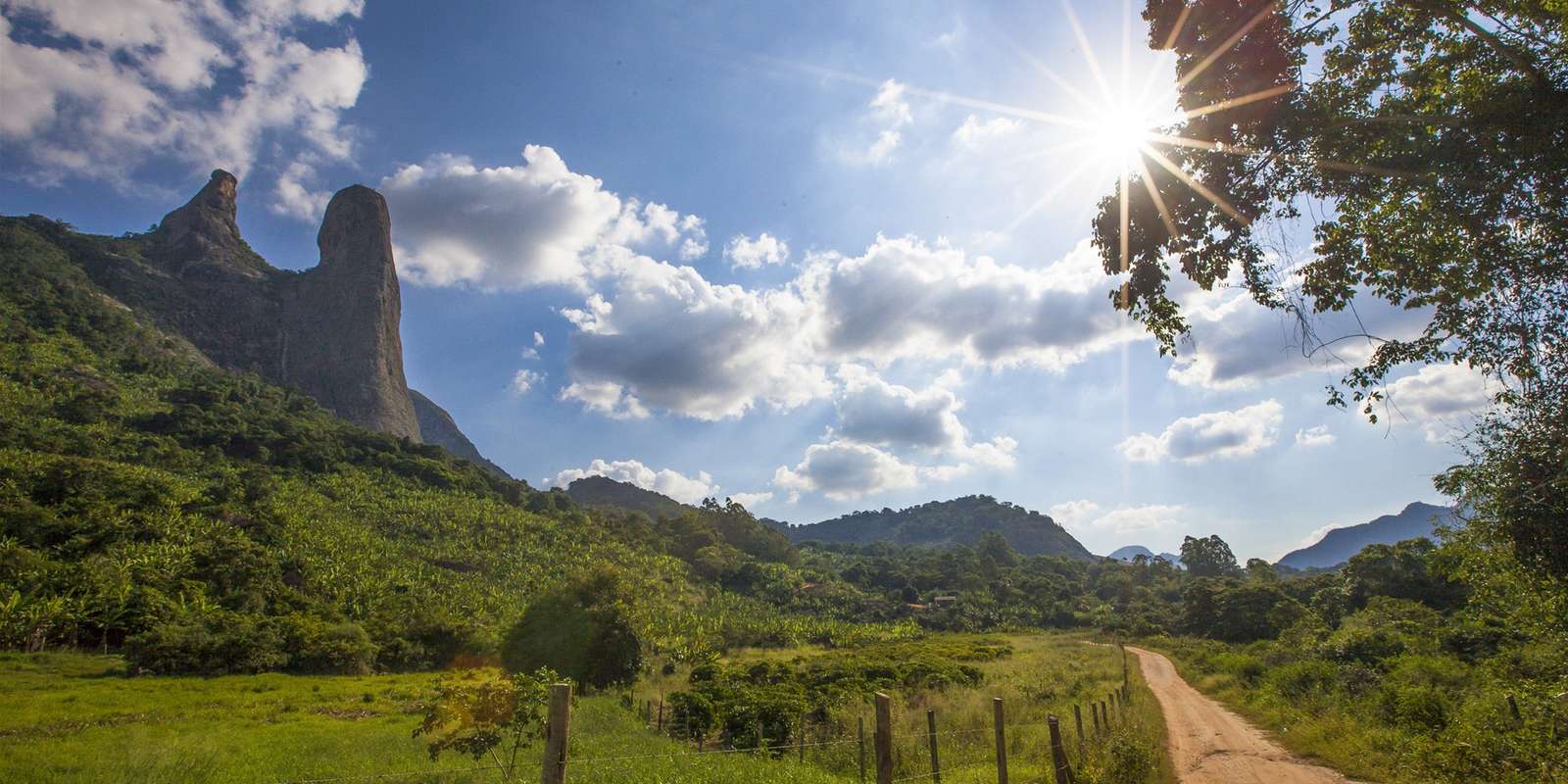 O Frade e a Freira, formação de granito entre Vargem Alta e Itapemirim, com pasto, cerca e estrada de terra em primeiro plano